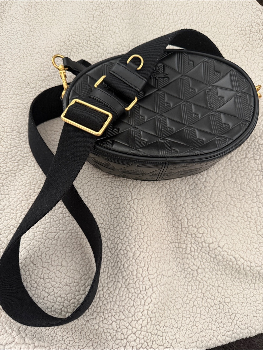 Lacoste Black Quilted Oval Crossbody Bag with Gold Hardware.